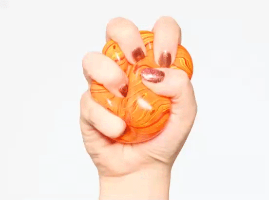 A woman squeezes a stress ball. 