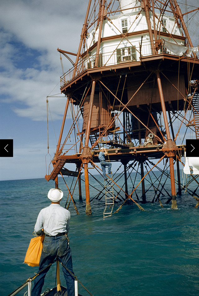 Seamen receive the mail drop from a small boat.  