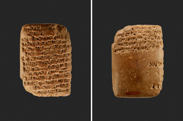 Clay tablet with cuneiform script on a dark background. The tablet's surface is covered with intricate, ancient inscriptions